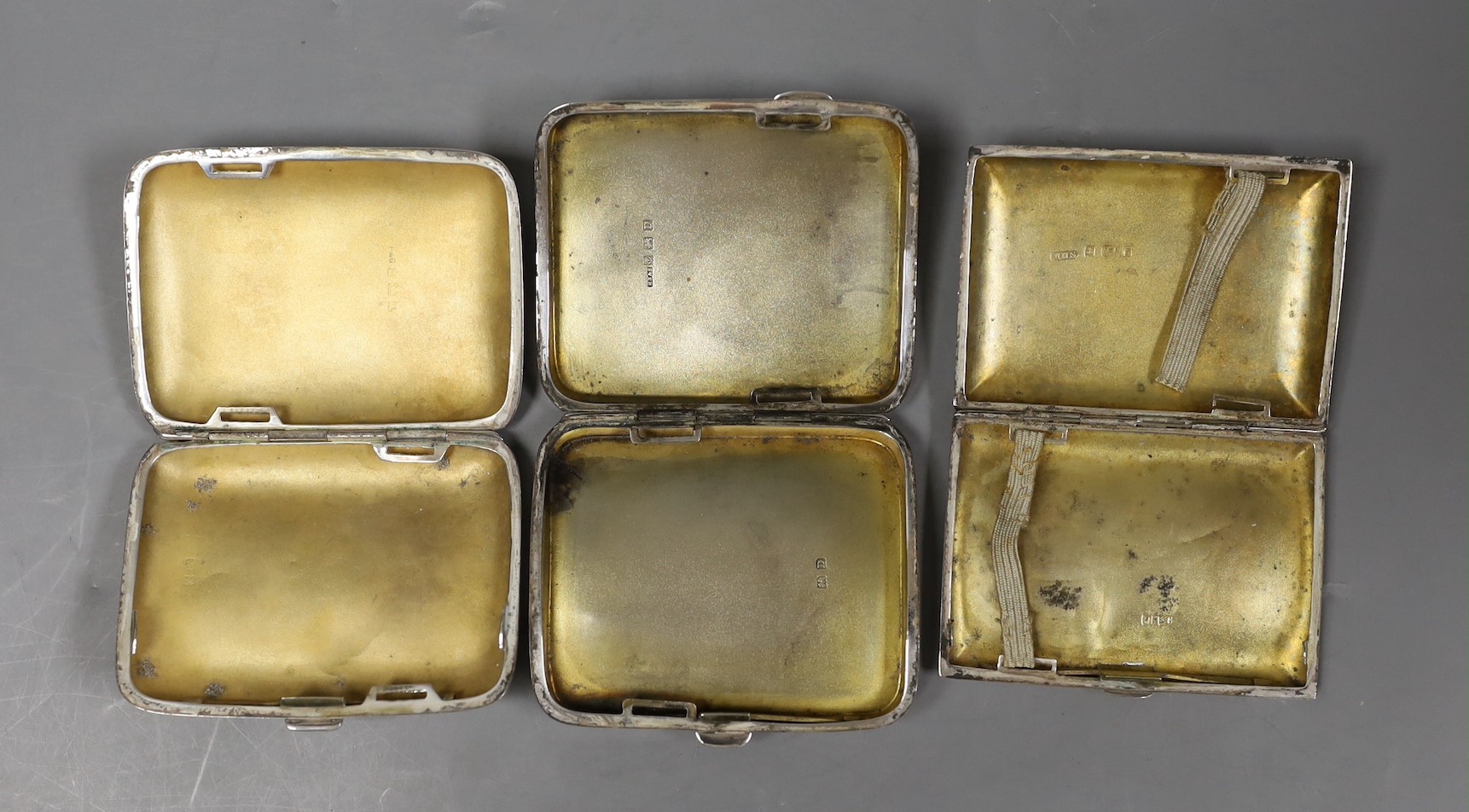 Three assorted engraved silver cigarette cases, largest 82mm.